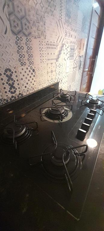 a stove top oven with a bunch of burners on it at FLAT a 2min do relogio da flores com ar condicionado in Garanhuns