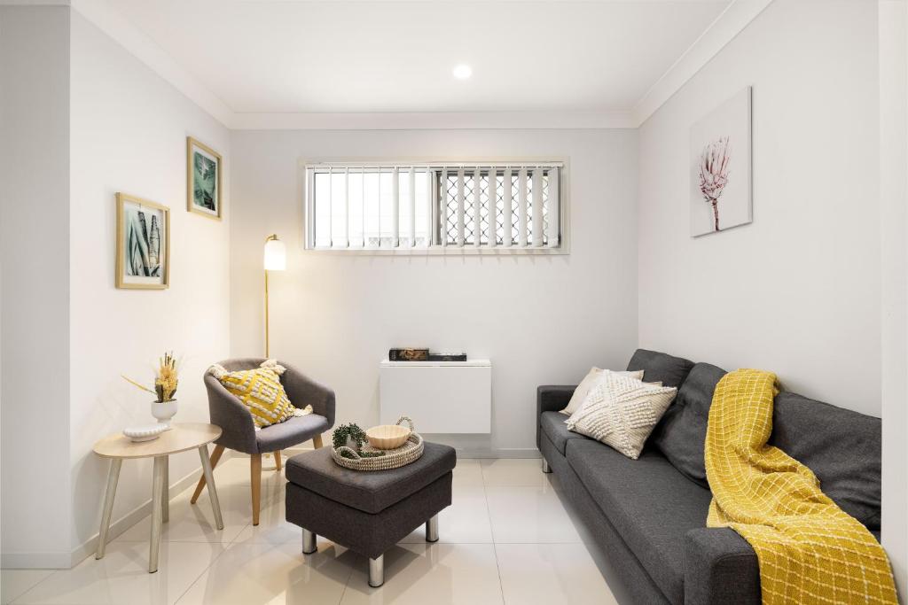 a living room with a couch and a table at Air-Con, Netflix, Close to Transport & Private in Brisbane