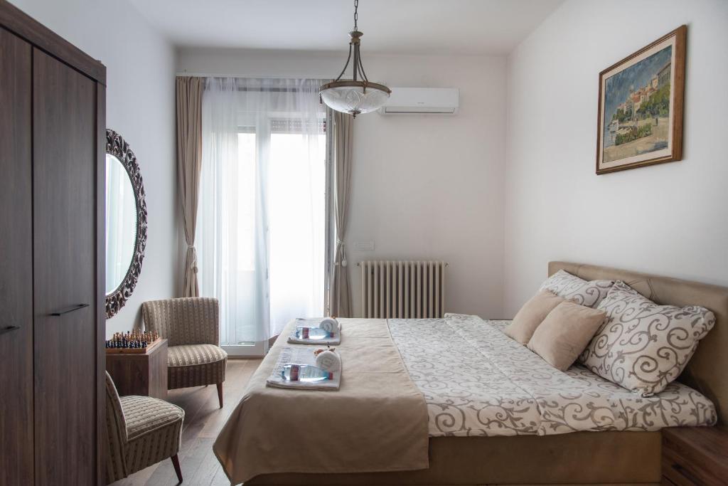 1 dormitorio con 1 cama, 1 silla y 1 ventana en Balkan dream **** en Belgrado