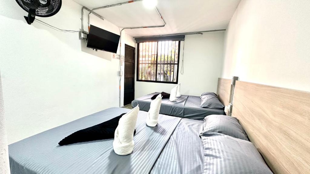 a bedroom with two beds and a flat screen tv at SINU LOFT in Medellín