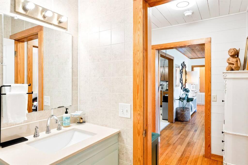 ein Badezimmer mit Waschbecken und Spiegel in der Unterkunft Sweet Tea Cottage-Cullman in Hanceville