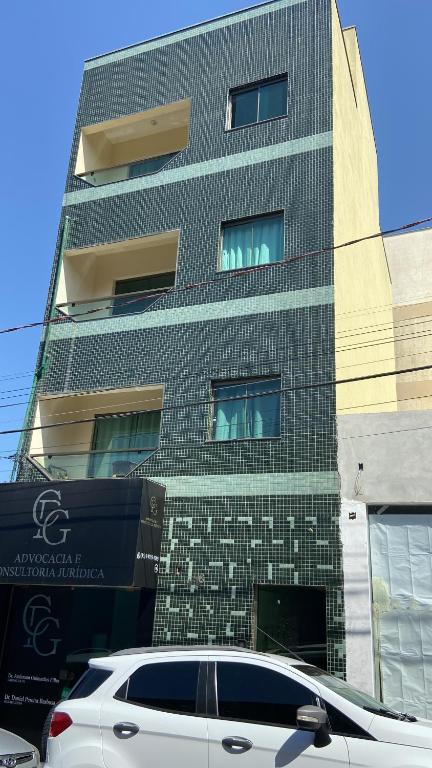 a white car parked in front of a building at Apartamento Centro Alfenas in Alfenas