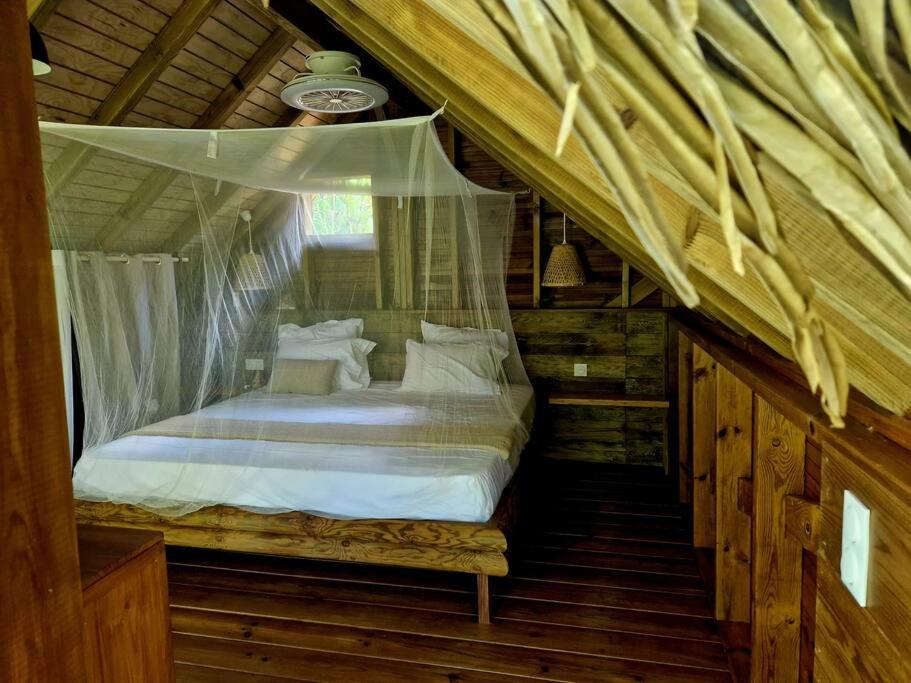 1 dormitorio con cama con dosel en una casa en Pura vida Lodge, en Sainte-Rose