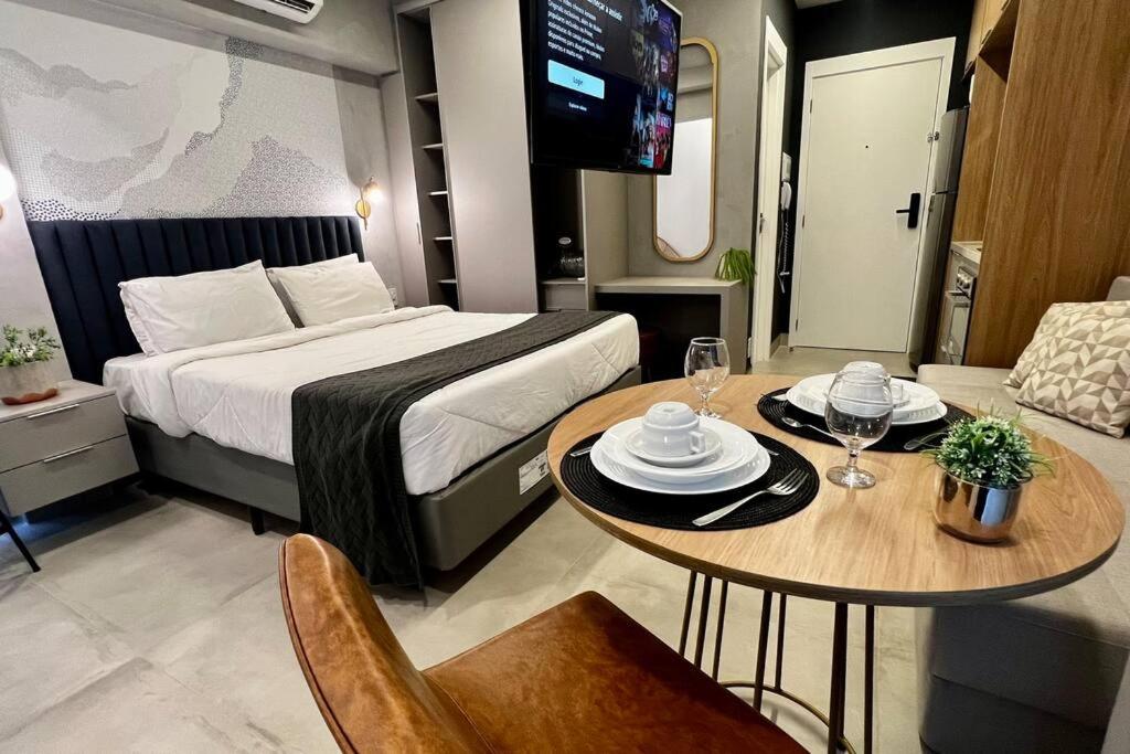 ein Hotelzimmer mit einem Bett und einem Tisch mit Stühlen in der Unterkunft Vitrali Deluxe Moema ao lado do metrô in São Paulo