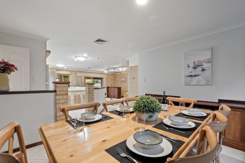 a dining room with a wooden table and chairs at Gem on Jones in Vasse