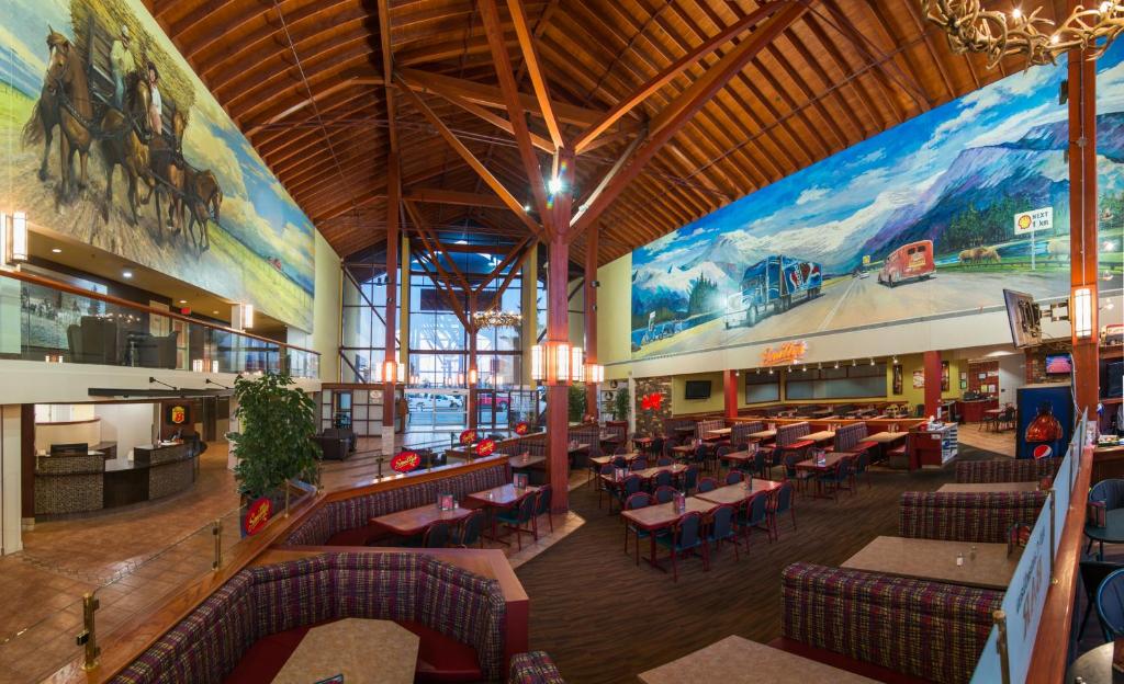 a restaurant with couches and tables and a large mural at Super 8 by Wyndham Sherwood Park/Edmonton Area in Sherwood Park