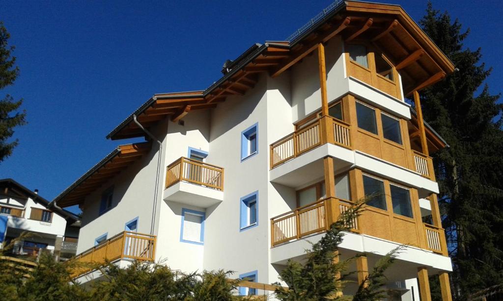 a white building with wooden balconies on it at Villa in Val di Fiemme in Cavalese