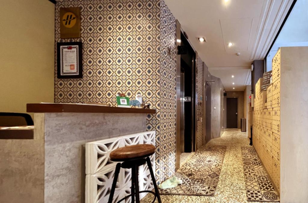 a bar with a stool next to a corridor at Funtime Hostel in Chiayi City