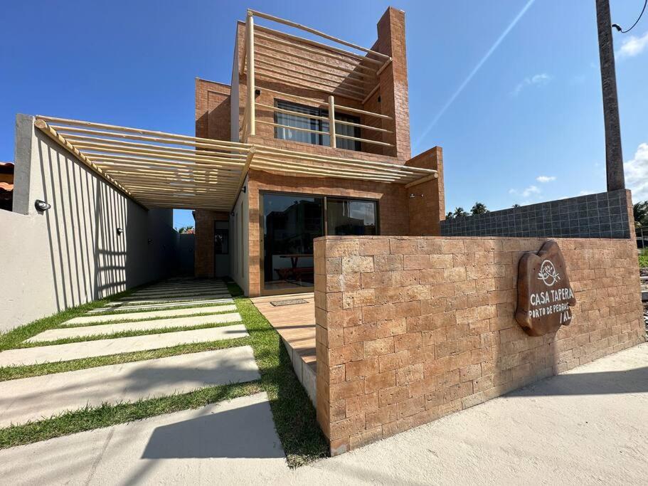 a brick building with a sign in front of it at Casa Tapera - Porto de Pedras/AL in Pôrto de Pedras