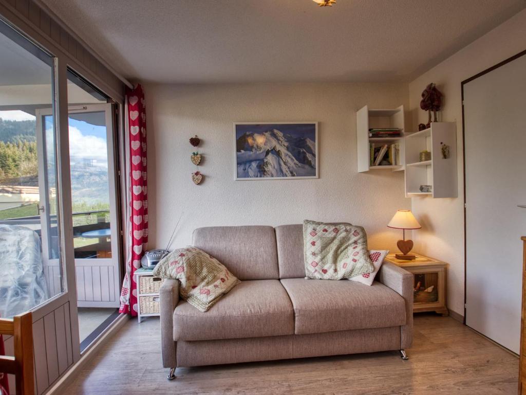 un salon avec un canapé et une grande fenêtre dans l'établissement Studio cosy Morillon 1100 avec balcon et casier à skis - FR-1-642-83, à Morillon