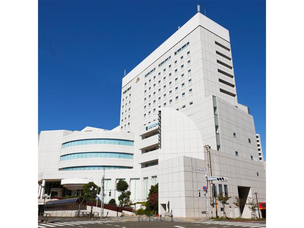 ein großes weißes Gebäude mit vielen Fenstern in der Unterkunft Rembrandt Hotel Tokyo-Machida in Machida