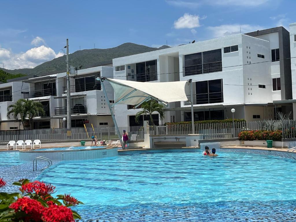 two people in a swimming pool in front of a building at Apartasol en Santa Fe de Antioquia in Santa Fe de Antioquia