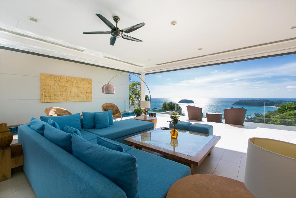 a living room with blue furniture and a large window at The heights Penthouse Ocean view A11 in Kata Beach