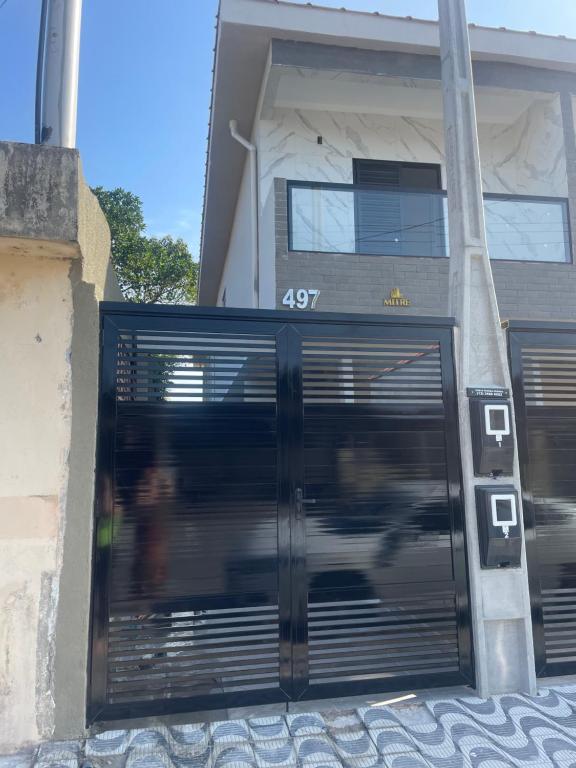 une porte menant à un bâtiment avec des gens qui le traversent dans l'établissement Casa novinha - Praia Grande - Mirim - 3 quadras da Praia Wi-Fi, à Praia Grande