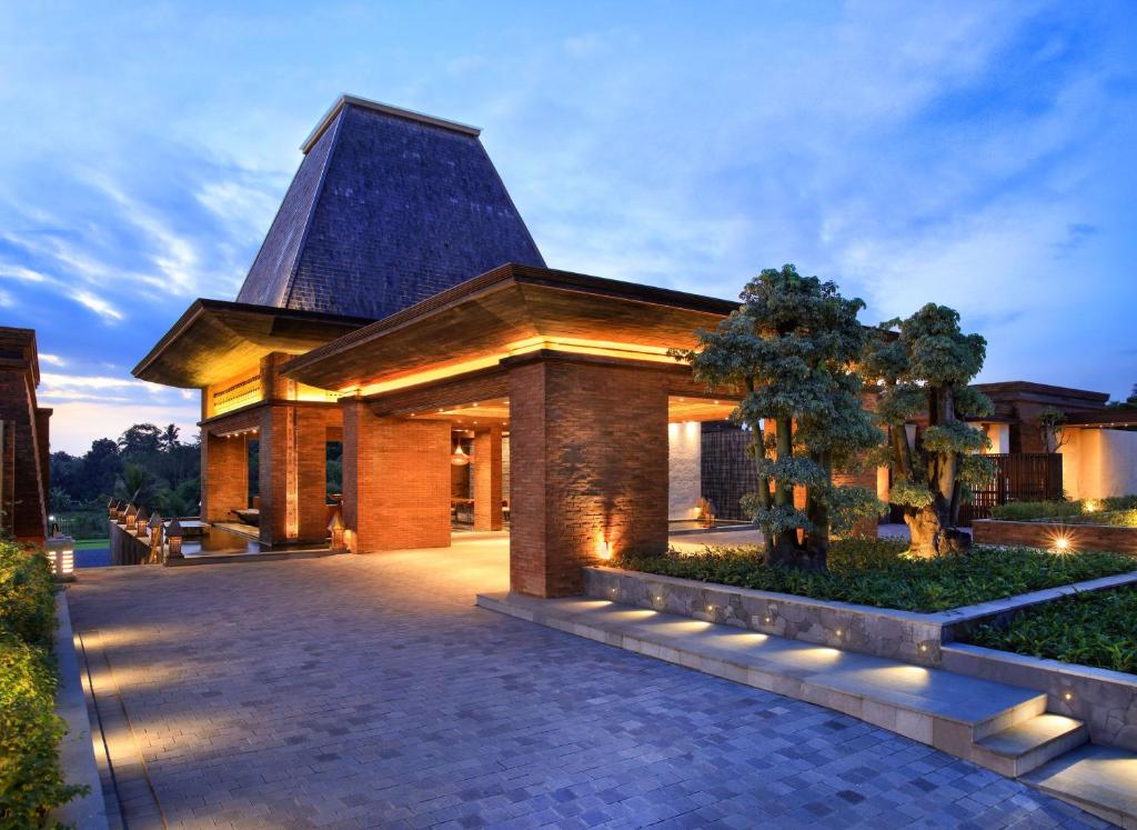 een groot gebouw met een puntdak met verlichting bij Garrya Bianti Yogyakarta in Yogyakarta