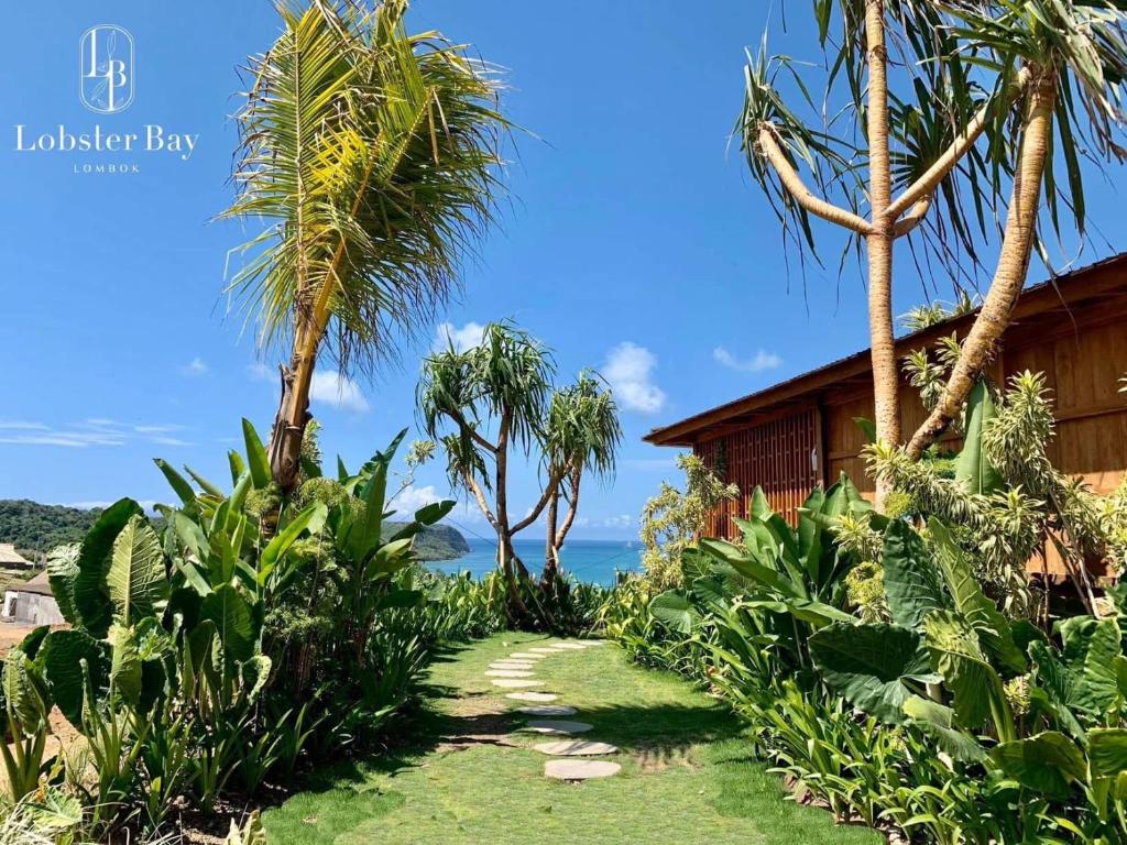 a path in front of a house with palm trees at Lobster Bay Lombok in Awang