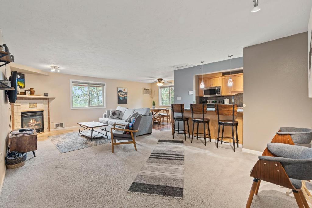 a living room and kitchen with a couch and a table at Modern Amenities Gas Fireplace Central Location in Spokane