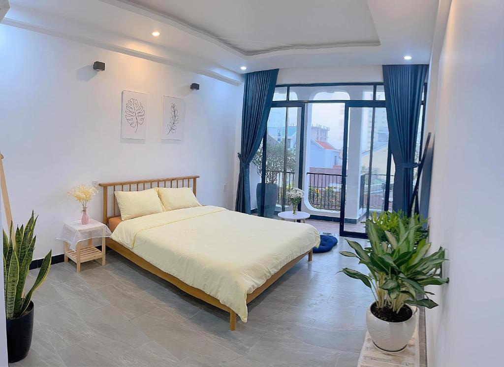 a bedroom with a bed and a large window at Le Petit Homestay in Hue