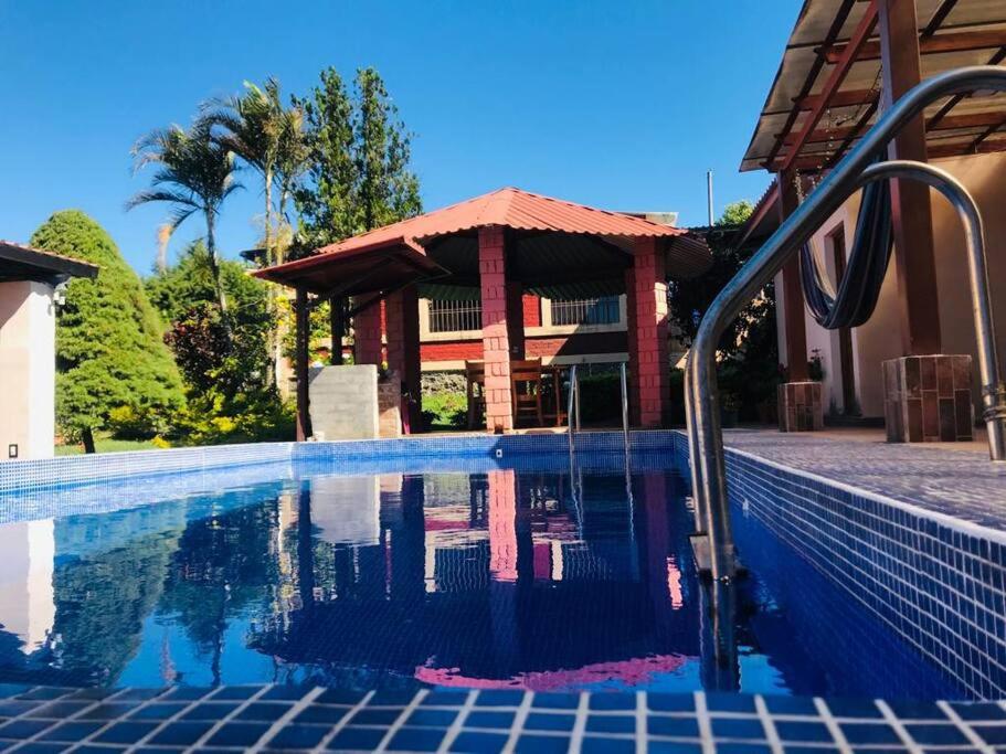 een zwembad met een prieel naast een huis bij Los Cipreses-10persons-Deep connection with nature 