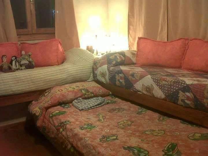 sala de estar con sofá y cama en Cabañas en Mar Azul en Balneario Mar Azul