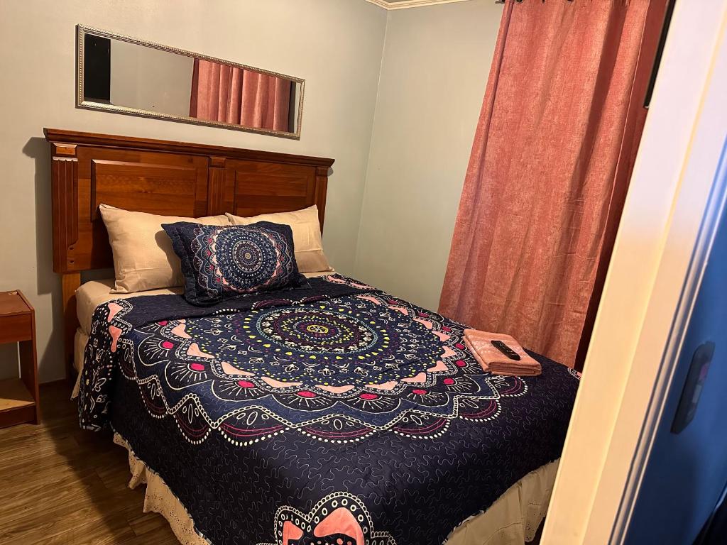 um quarto com uma cama com um cobertor e um espelho em Apartamentos Orquídea Suite em Santiago