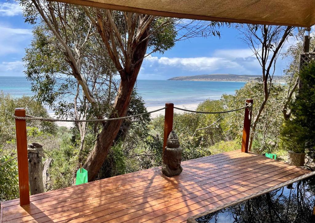 a wooden deck with a view of the ocean at Rumah Pantai in Emu Bay