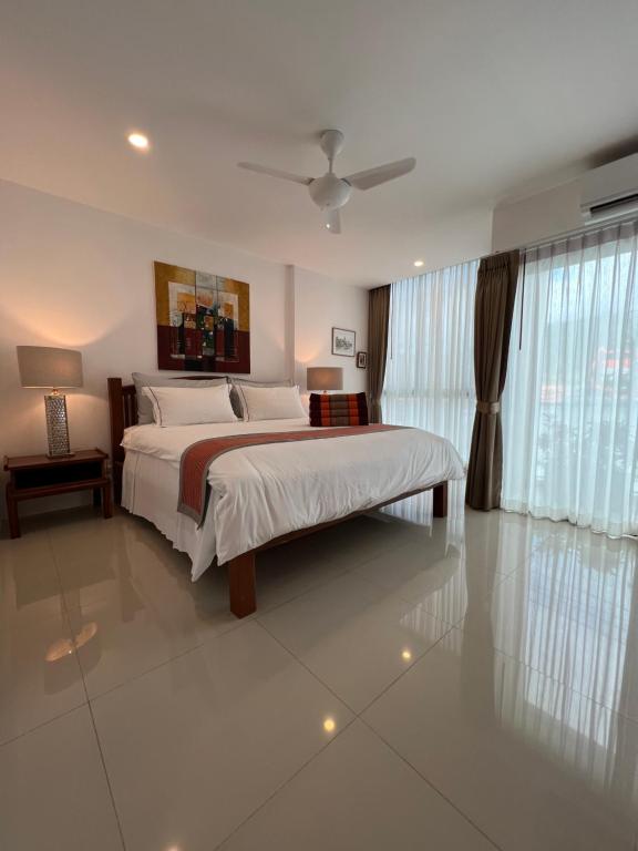 una camera con un grande letto e una grande finestra di Super Som Rawai a Rawai Beach
