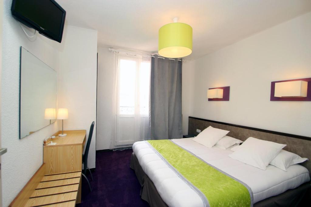 Postel nebo postele na pokoji v ubytování Hôtel Peyramale
