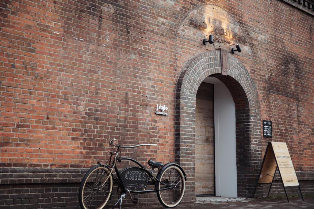 ein Fahrrad wird neben einer Backsteinmauer geparkt in der Unterkunft Lampstand STAY Asahikawa in Asahikawa