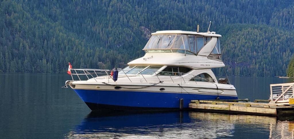 um barco azul e branco sentado na água em GYPSIES DRIFTER em Vancouver