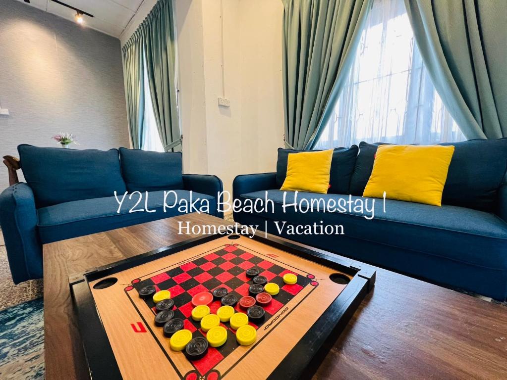 uma sala de estar com um sofá azul e um tabuleiro de xadrez em Traveler homestay paka 3-6pax in front Surau and near Paka Beach - Y2L Homestay 1 em Paka