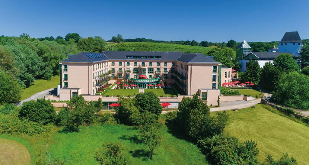 eine Luftansicht eines Gebäudes mit Garten in der Unterkunft Victor's Residenz-Hotel Schloss Berg in Nennig