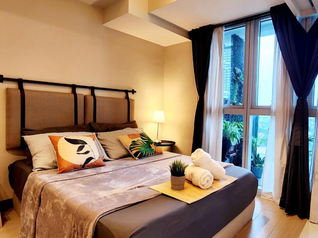 a bedroom with a bed with a large window at Cozy Minimalist Unit at BGC Mall Free Parking in Manila