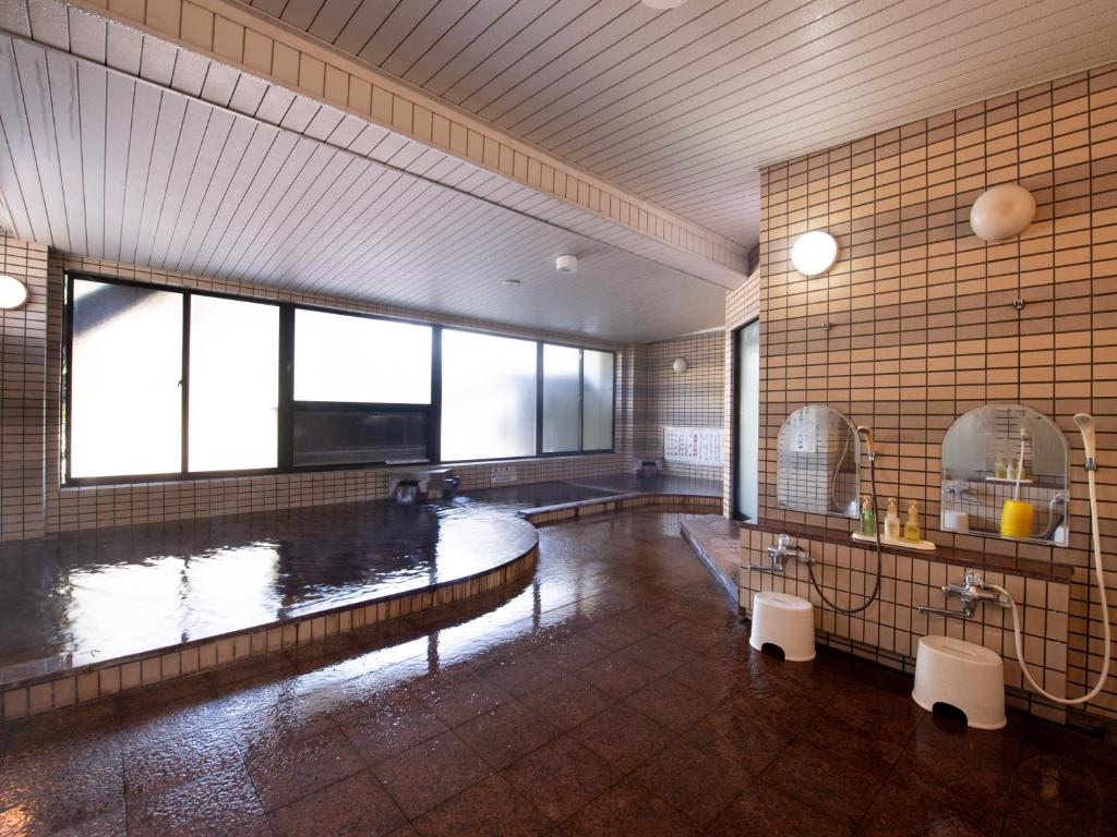 a large bathroom with a large pool of water at Tabist Hotel Yamashiro Onsen in Kofu