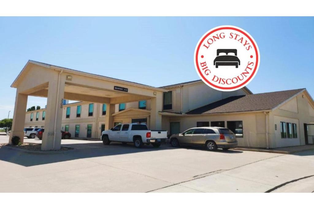 a large building with cars parked in front of it at McPherson Inn By OYO, I-135 in McPherson