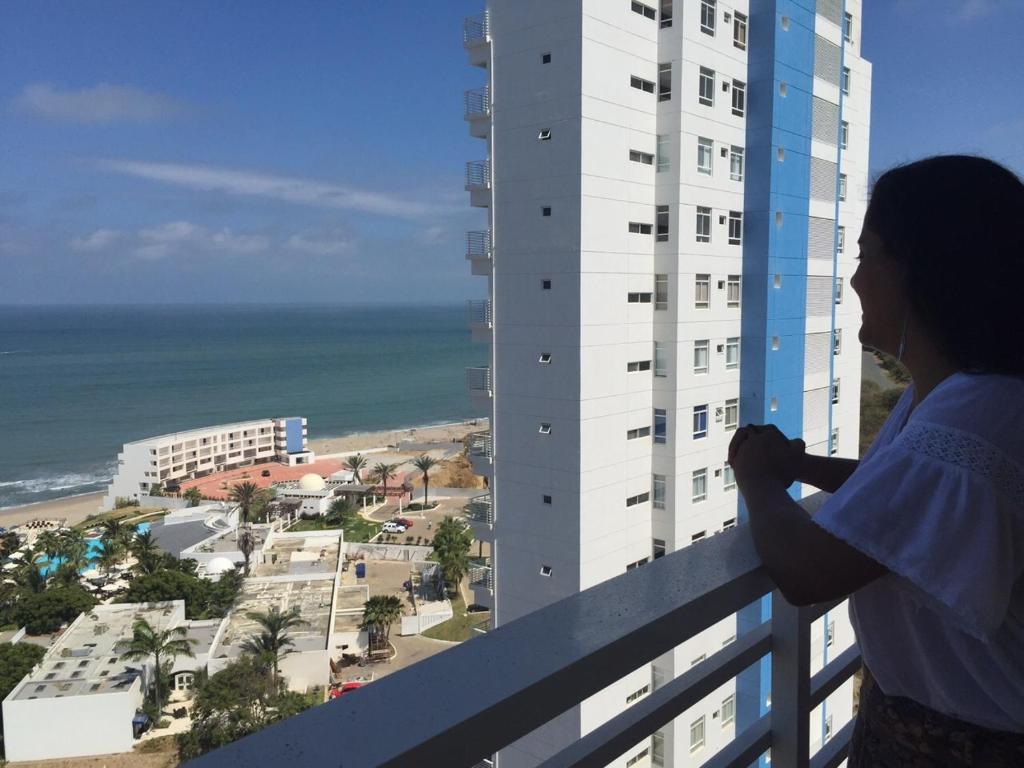 a woman standing on a balcony looking out at the ocean at Ocean View in Playas