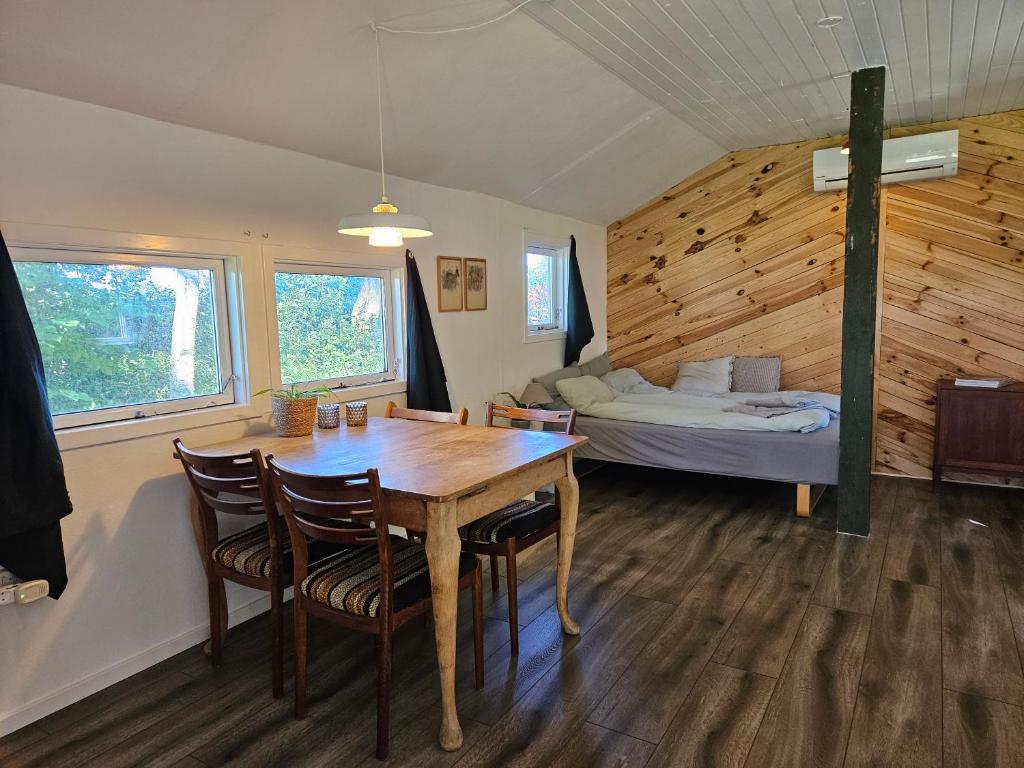 um quarto com uma mesa e cadeiras e uma cama em The Cottage em Brædstrup