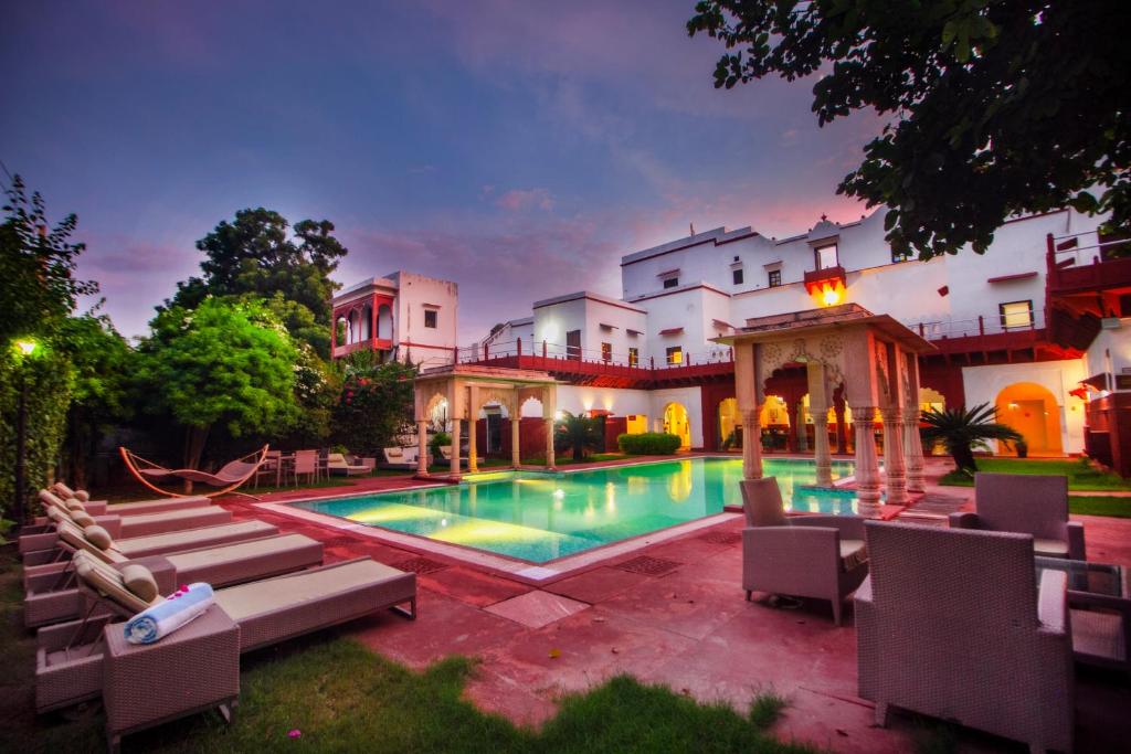 a large house with a swimming pool in the yard at Amritara Chandra Mahal Haveli, Bharatpur in Bharatpur