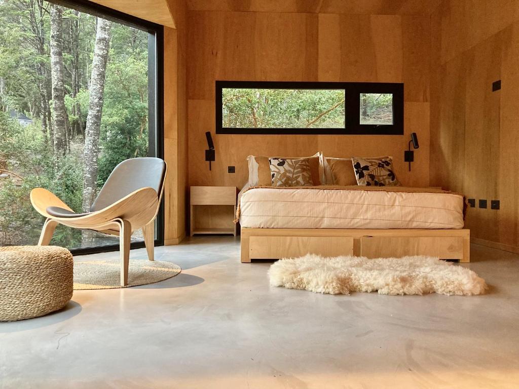- une chambre avec un lit, une chaise et une fenêtre dans l'établissement Casa Gallareta , luxury con costa del lago ., à Villa La Angostura