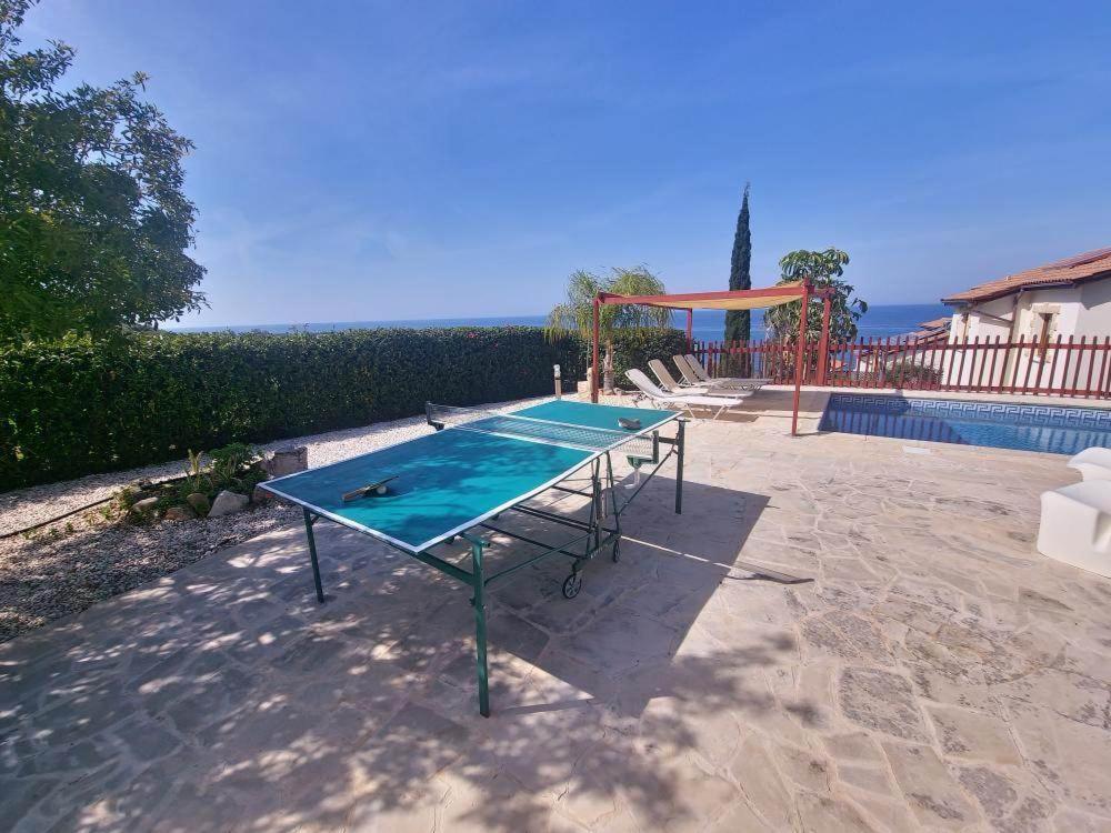 a ping pong table in front of a swimming pool at Pomos Harbourbiew Villa in Pomos