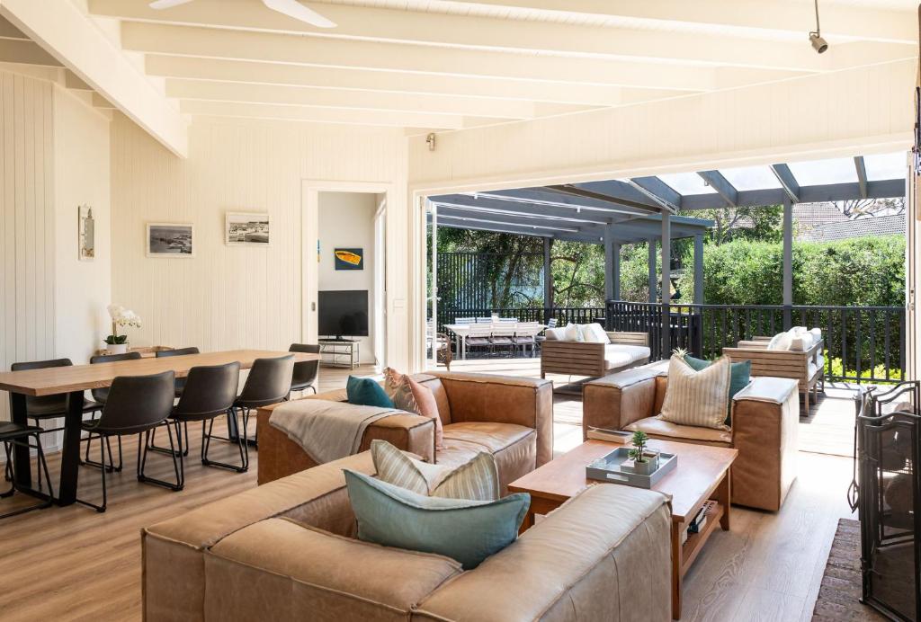a living room with couches and a table and chairs at Hayden Beach House in Portsea in Portsea