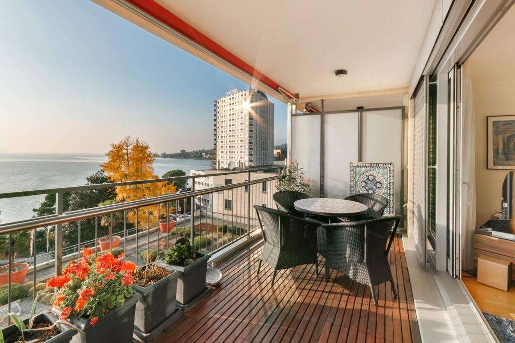 a balcony with a table and a view of the water at Alpes - Large apartment with amazing view on Lake Geneva in Montreux