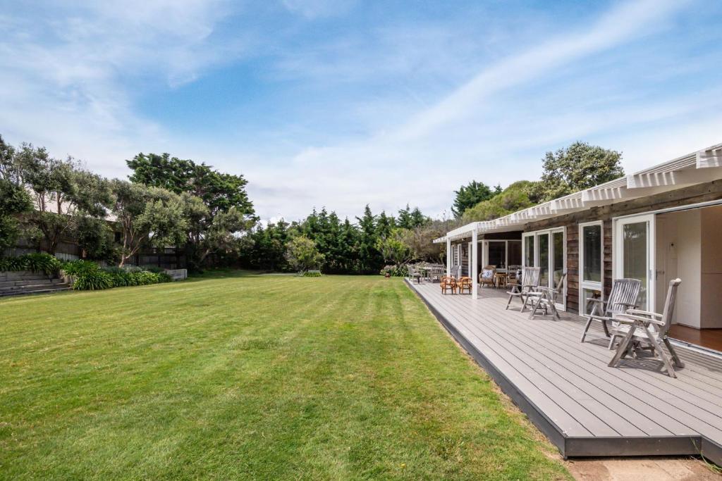 an outdoor deck with chairs and a yard at Blairgowrie Beauty By The Beach in Blairgowrie