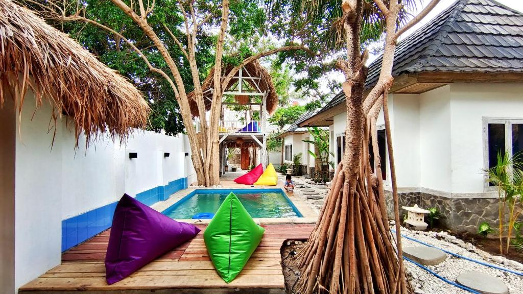 a pool with colorful pillows next to a house at Panda Home in Gili Trawangan