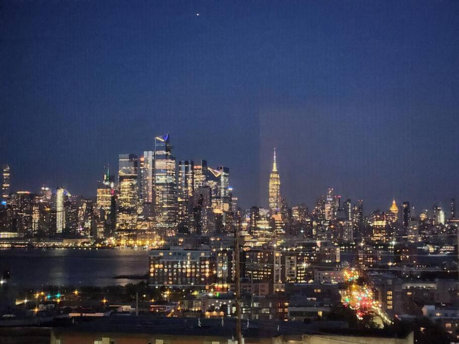 a night view of a city with a lit up skyline at Luxurious 2 bed ! mins to NYC! in Union City