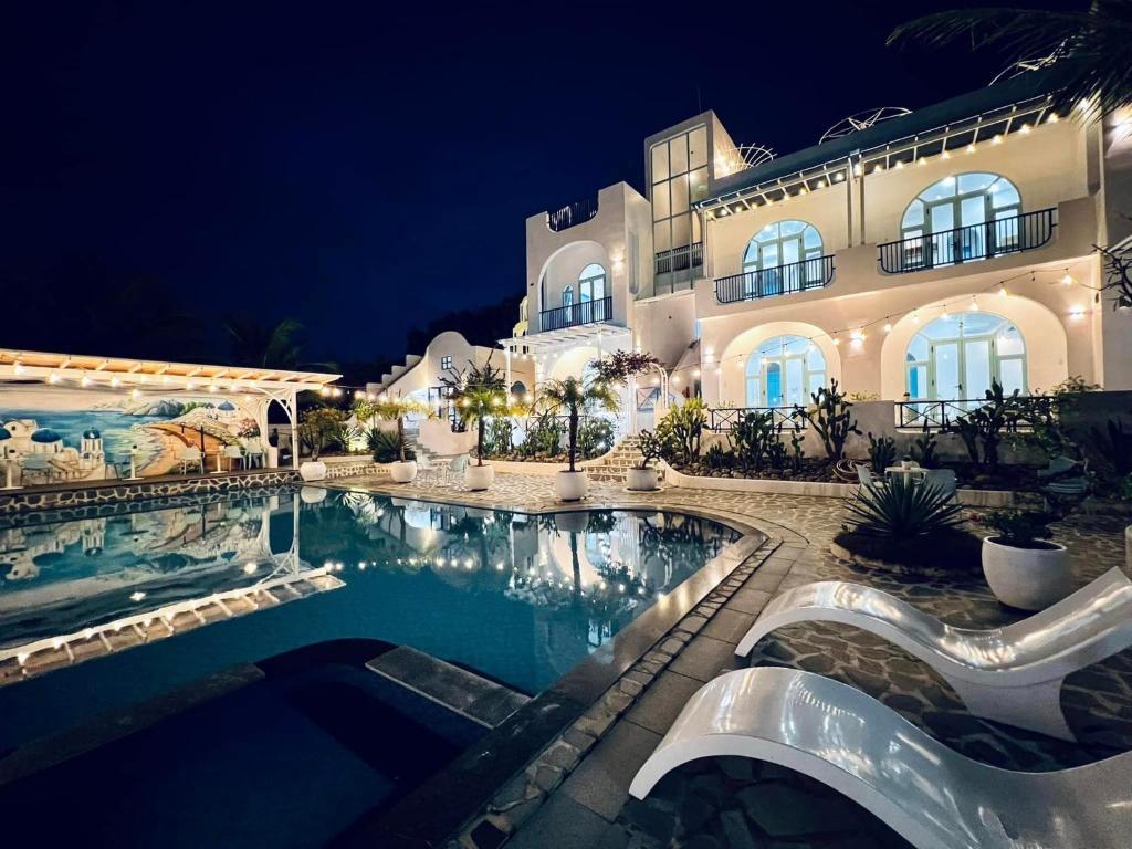 a large house with a swimming pool at night at Santorini Villa Cam Ranh in Cam Ranh