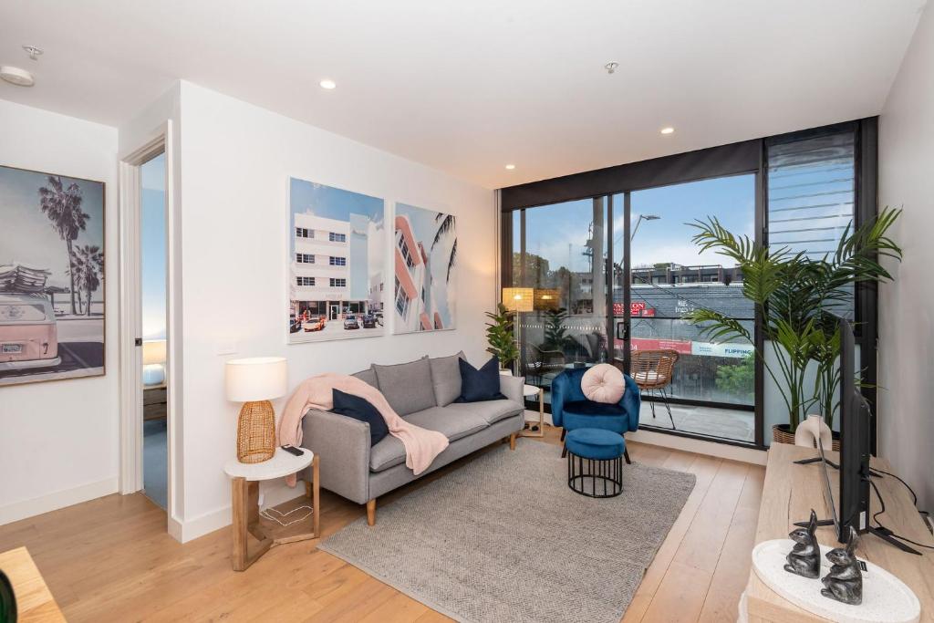 a living room with a couch and a large window at Bayside living at The Hampton in Melbourne