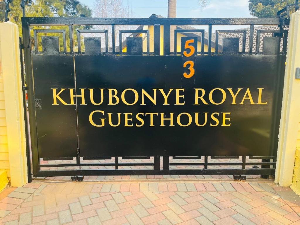 una señal en una puerta que dice que es la casa de huéspedes real en Khubonye Royal Guesthouse, en Randjesfontein