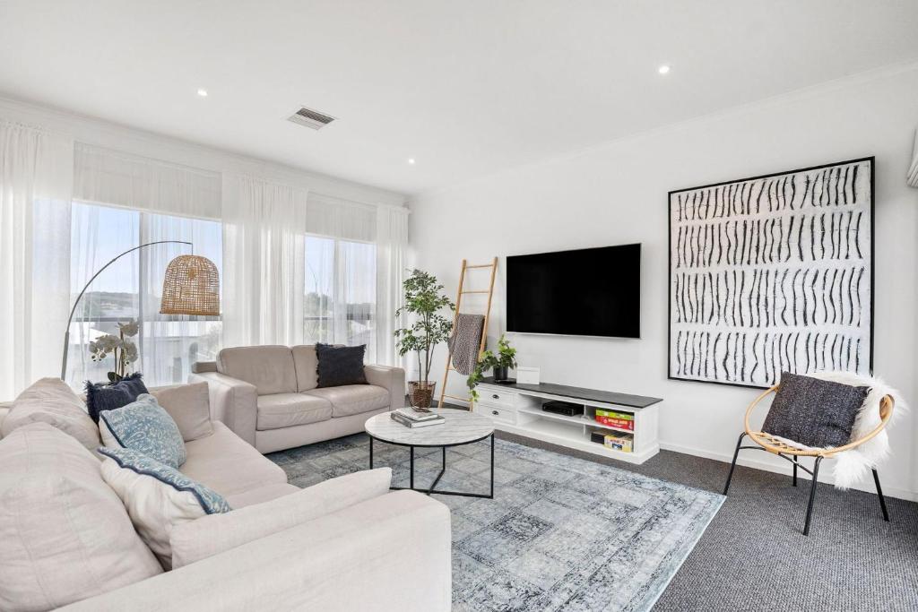 un salon blanc avec un canapé et une télévision dans l'établissement Darling Villa Biani in Sorrento with Spa, à Sorrento