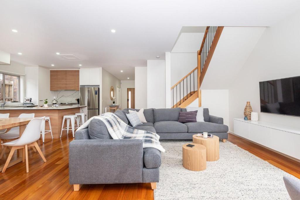 ein Wohnzimmer mit einer grauen Couch und einer Küche in der Unterkunft Casa Blue in Dromana in Dromana